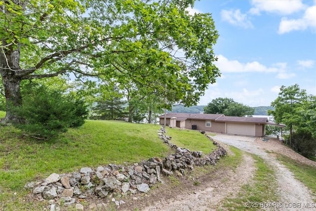97 Random Rd, Edwards, MO 65326 - ranch-style home with dirt driveway, a garage, and a front yard
