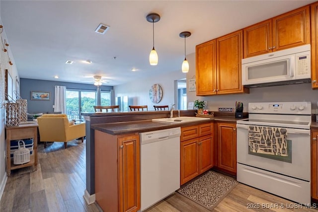 1481 Ledges Dr Unit C24, Osage Beach, MO 65065 - kitchen with white appliances, brown cabinetry, a peninsula, light wood-type flooring, and recessed lighting