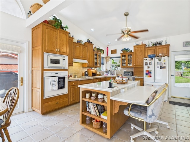 1620 Triple Cove Ln, Climax Springs, MO 65324 - kitchen with white appliances, brown cabinetry, light countertops, backsplash, and recessed lighting