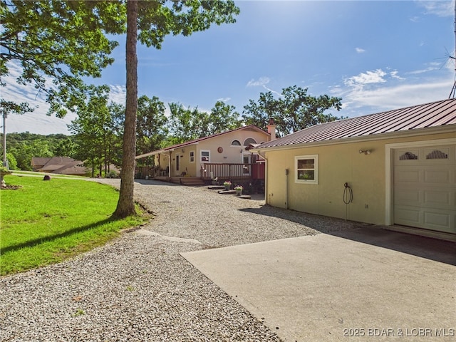 1620 Triple Cove Ln, Climax Springs, MO 65324 - view of side of property with a standing seam roof, a metal roof, stucco siding, a deck, and driveway