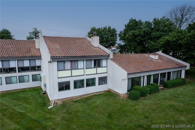 35 Casa Blanca Ct Unit 220-1A, Lake Ozark, MO 65049 - rear view of house featuring a chimney, a tiled roof, and a yard
