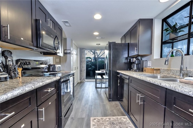 35 Casa Blanca Ct Unit 220-1A, Lake Ozark, MO 65049 - kitchen with black appliances, light wood-style flooring, light stone countertops, and recessed lighting