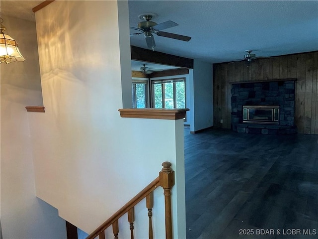 192 Ke Jo Point Rd, Gravois Mills, MO 65037 - living room featuring dark wood finished floors, a stone fireplace, ceiling fan, and wooden walls