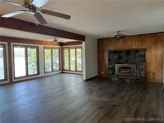 192 Ke Jo Point Rd, Gravois Mills, MO 65037 - unfurnished living room with wooden walls, dark wood finished floors, a textured ceiling, a ceiling fan, and a fireplace