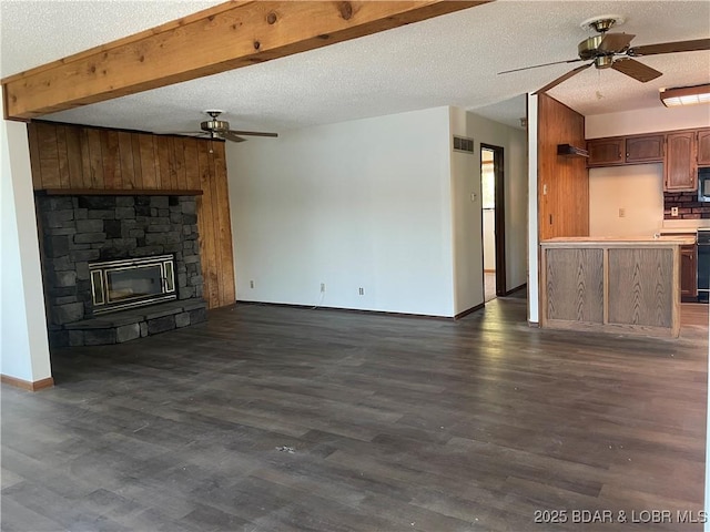 192 Ke Jo Point Rd, Gravois Mills, MO 65037 - unfurnished living room with a ceiling fan, dark wood-style flooring, a textured ceiling, a stone fireplace, and beamed ceiling