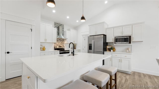 3164 Cross Creek Dr, Camdenton, MO 65020 - kitchen with appliances with stainless steel finishes, tasteful backsplash, wall chimney exhaust hood, light wood-style flooring, and white cabinetry