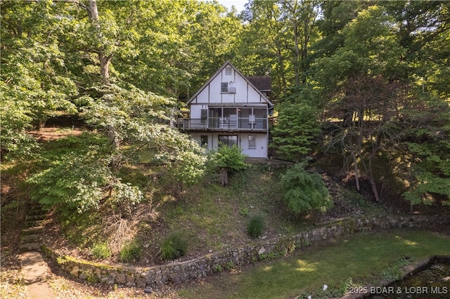 15617 Santa Fe Trl, Gravois Mills, MO 65037 - view of home's exterior with a balcony and a wooded view