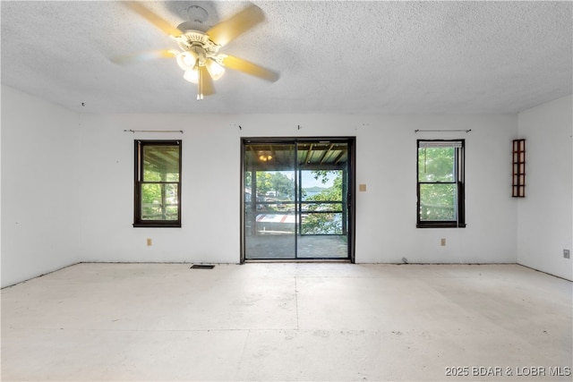 15617 Santa Fe Trl, Gravois Mills, MO 65037 - unfurnished room with a textured ceiling, a ceiling fan, and concrete floors