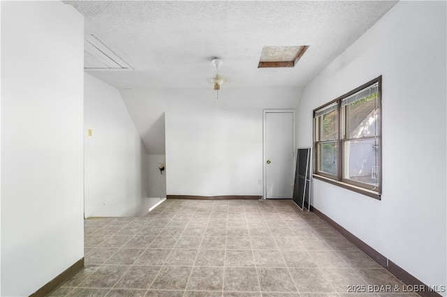 15617 Santa Fe Trl, Gravois Mills, MO 65037 - empty room featuring a textured ceiling, vaulted ceiling, and attic access