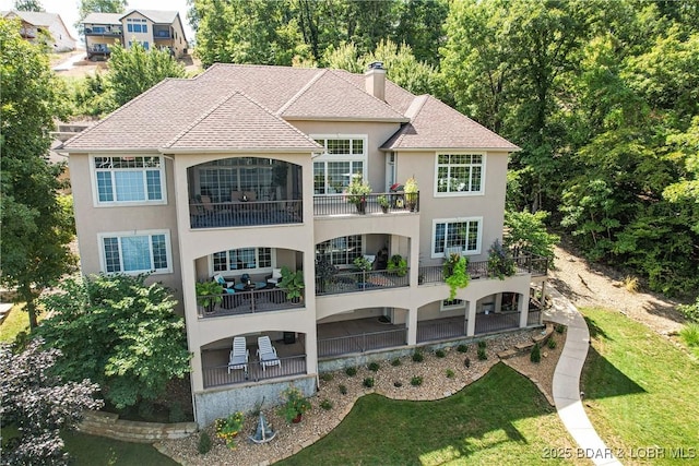 1163 Beacon Pointe Cir, Lake Ozark, MO 65049 - rear view of property with stucco siding, a chimney, a yard, and a shingled roof