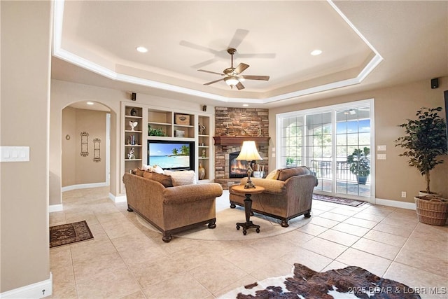 1163 Beacon Pointe Cir, Lake Ozark, MO 65049 - living area with a raised ceiling, arched walkways, ceiling fan, light tile patterned floors, and built in features
