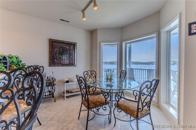 492 Regatta Bay Dr Unit 2D, Lake Ozark, MO 65049 - dining space featuring light tile patterned floors, a water view, and track lighting