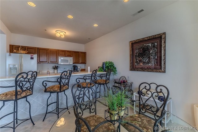 492 Regatta Bay Dr Unit 2D, Lake Ozark, MO 65049 - kitchen with white appliances, a kitchen breakfast bar, recessed lighting, light countertops, and light tile patterned flooring