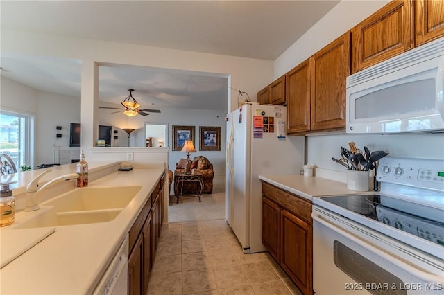 492 Regatta Bay Dr Unit 2D, Lake Ozark, MO 65049 - kitchen with white appliances, brown cabinetry, light countertops, a ceiling fan, and light tile patterned floors