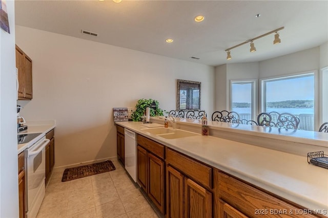 492 Regatta Bay Dr Unit 2D, Lake Ozark, MO 65049 - kitchen featuring white appliances, light countertops, brown cabinets, and recessed lighting