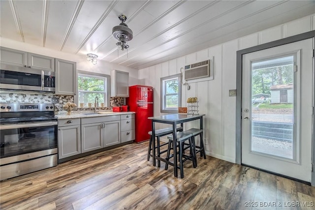 54 White Rock Ln, Sunrise Beach, MO 65079 - kitchen with stainless steel appliances, gray cabinets, backsplash, and wood finished floors