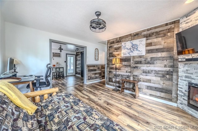 54 White Rock Ln, Sunrise Beach, MO 65079 - living room with wooden walls, wood finished floors, a fireplace, and an office area