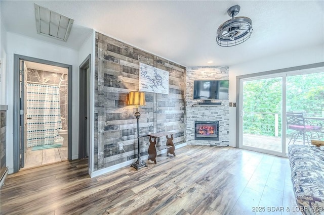54 White Rock Ln, Sunrise Beach, MO 65079 - living room with a fireplace, wood finished floors, and wood walls