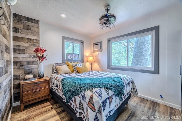 54 White Rock Ln, Sunrise Beach, MO 65079 - bedroom with light wood-type flooring, a textured ceiling, and an AC wall unit