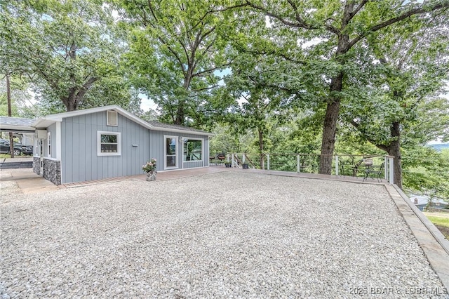 54 White Rock Ln, Sunrise Beach, MO 65079 - rear view of house featuring board and batten siding and stone siding