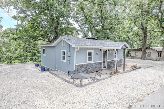 54 White Rock Ln, Sunrise Beach, MO 65079 - view of front of property with stone siding, roof with shingles, and covered porch