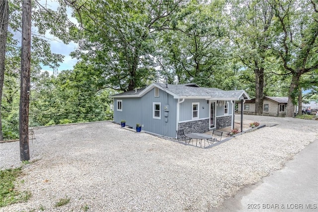54 White Rock Ln, Sunrise Beach, MO 65079 - view of front of property featuring stone siding, gravel driveway, and a shingled roof