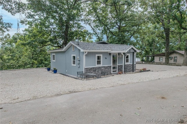54 White Rock Ln, Sunrise Beach, MO 65079 - view of front facade featuring stone siding, driveway, and a shingled roof