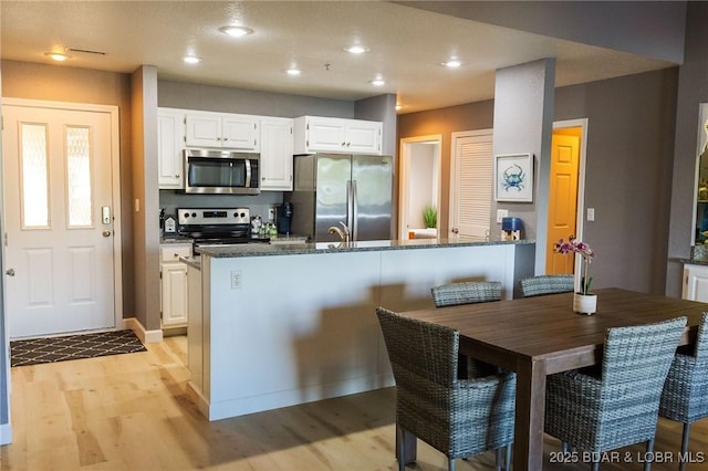 46 Aqua Fin Dr Unit 4A, Lake Ozark, MO 65049 - kitchen with stainless steel appliances, light wood-style flooring, a peninsula, white cabinetry, and recessed lighting