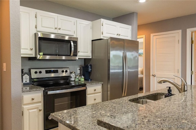 46 Aqua Fin Dr Unit 4A, Lake Ozark, MO 65049 - kitchen featuring appliances with stainless steel finishes, light stone counters, and white cabinetry