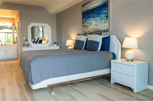 46 Aqua Fin Dr Unit 4A, Lake Ozark, MO 65049 - bedroom with light wood-style floors, lofted ceiling, and ensuite bath