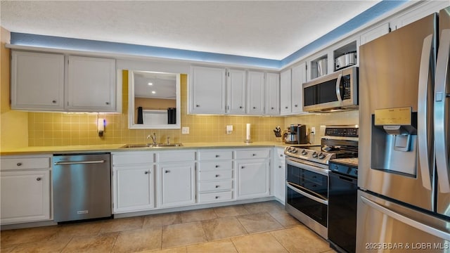 161 Tanglewood Dr, Camdenton, MO 65020 - kitchen with stainless steel appliances, light countertops, tasteful backsplash, and white cabinetry