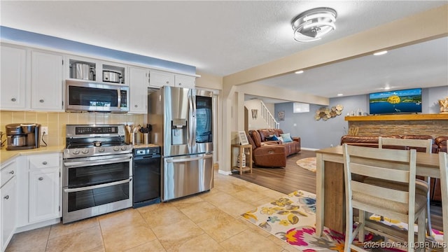 161 Tanglewood Dr, Camdenton, MO 65020 - kitchen featuring stainless steel appliances, light countertops, open floor plan, white cabinetry, and decorative backsplash