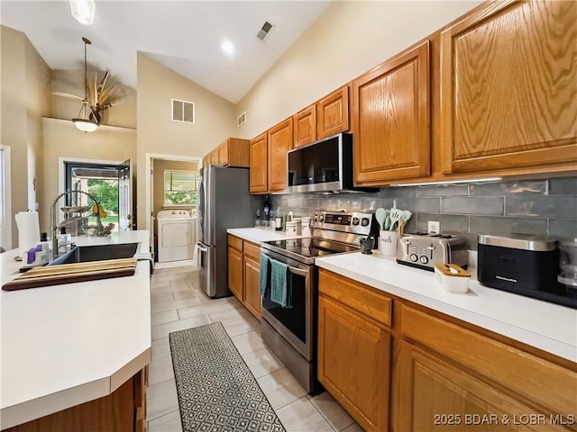 110 Golf View Dr, Camdenton, MO 65020 - kitchen featuring stainless steel appliances, washer / clothes dryer, tasteful backsplash, light countertops, and light tile patterned floors