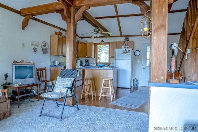 4230 Fox Hollow Ln, Stover, MO 65078 - kitchen with freestanding refrigerator, light wood-style flooring, a ceiling fan, a kitchen breakfast bar, and a peninsula