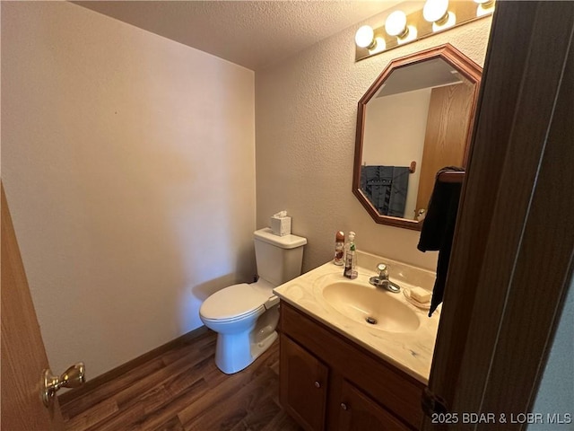 30024 Hawaii Rd, Gravois Mills, MO 65037 - half bathroom featuring wood finished floors, vanity, a textured wall, and a textured ceiling