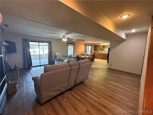 30024 Hawaii Rd, Gravois Mills, MO 65037 - living room featuring light wood-style flooring, a textured ceiling, a ceiling fan, a fireplace, and recessed lighting