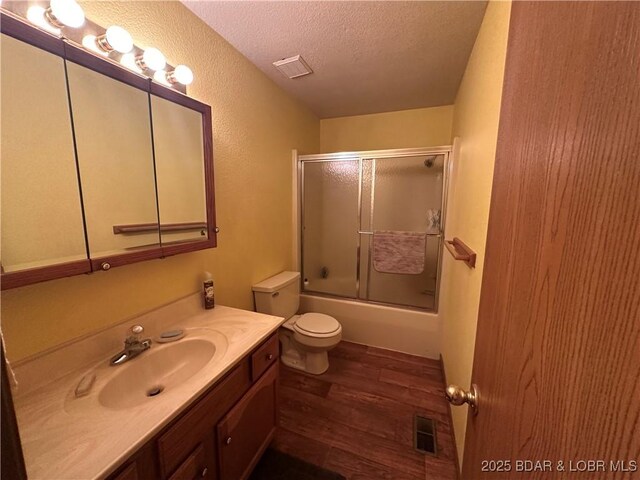 30024 Hawaii Rd, Gravois Mills, MO 65037 - bathroom featuring a textured ceiling, wood finished floors, vanity, and shower / bath combination with glass door