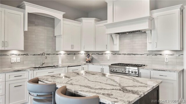 777 Malibu Rd, Osage Beach, MO 65065 - kitchen with gas range, white cabinets, tasteful backsplash, and a center island