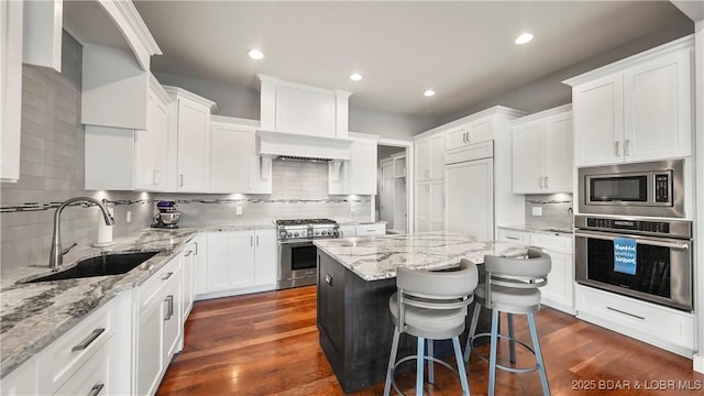 777 Malibu Rd, Osage Beach, MO 65065 - kitchen with built in appliances, decorative backsplash, white cabinetry, a kitchen island, and recessed lighting