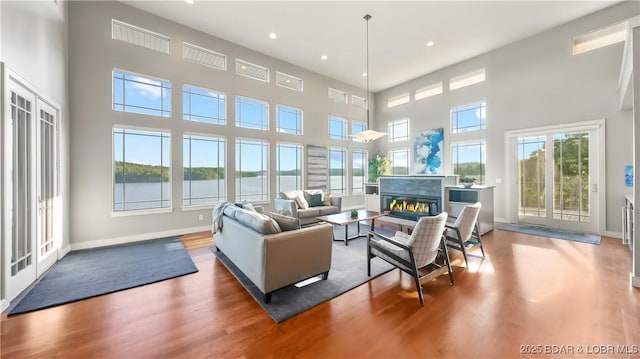 777 Malibu Rd, Osage Beach, MO 65065 - living room featuring a high ceiling, wood finished floors, recessed lighting, and a glass covered fireplace