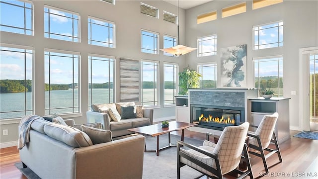 777 Malibu Rd, Osage Beach, MO 65065 - living room with wood finished floors, a towering ceiling, a tile fireplace, and a water view