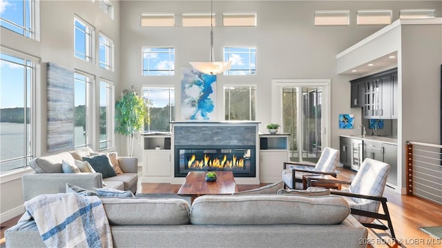 777 Malibu Rd, Osage Beach, MO 65065 - living area with wood finished floors, a high ceiling, a glass covered fireplace, and wine cooler