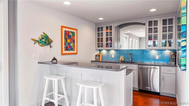 777 Malibu Rd, Osage Beach, MO 65065 - indoor wet bar featuring dishwasher, decorative backsplash, arched walkways, recessed lighting, and dark wood-type flooring