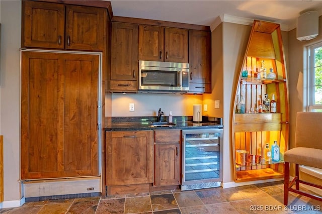 30310 Old Peony Rd, Gravois Mills, MO 65037 - kitchen featuring stainless steel microwave, beverage cooler, dark stone counters, crown molding, and brown cabinetry