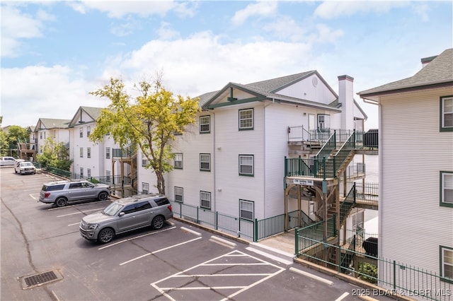 708 Harbour Towne Dr Unit E-708, Lake Ozark, MO 65049 - view of building exterior featuring stairway, uncovered parking, and a residential view