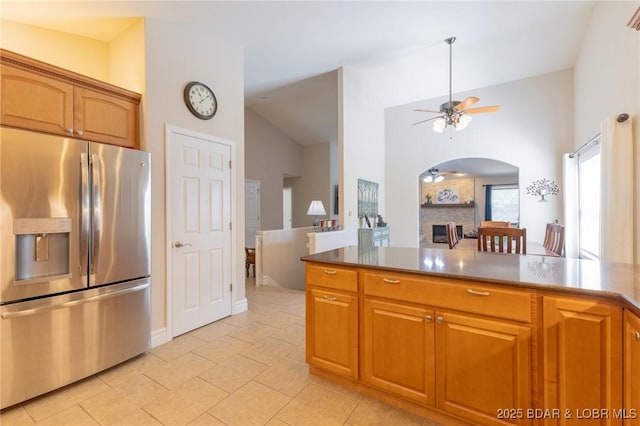 4331 Sunset Dr Unit B, Osage Beach, MO 65065 - kitchen featuring stainless steel fridge, arched walkways, a ceiling fan, lofted ceiling, and brown cabinetry