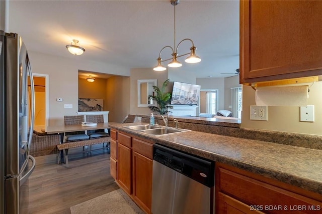 275 Flynn Rd Unit 105, Lake Ozark, MO 65049 - kitchen with stainless steel appliances, brown cabinets, dark wood-style flooring, dark countertops, and a ceiling fan