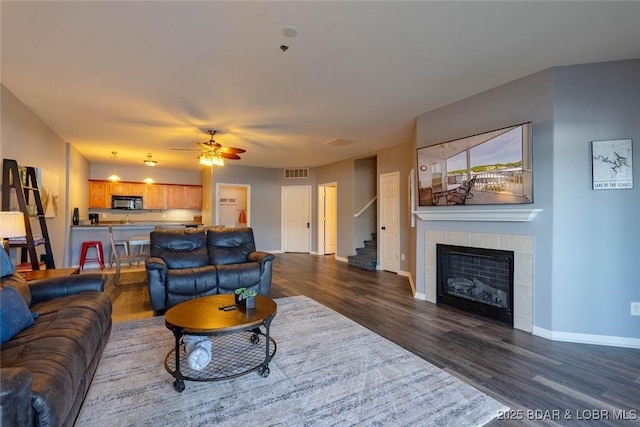 275 Flynn Rd Unit 105, Lake Ozark, MO 65049 - living area with dark wood-style floors, stairway, a tile fireplace, and ceiling fan