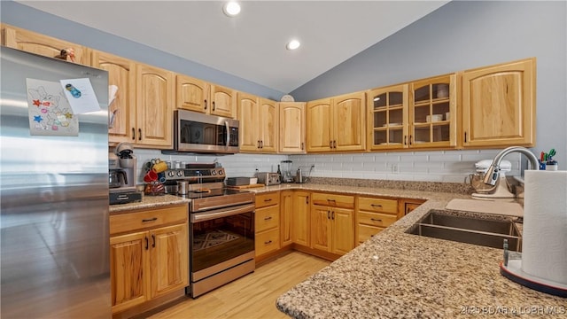 15 Knox Point Cir, Lake Ozark, MO 65049 - kitchen with stainless steel appliances, light wood-style floors, lofted ceiling, decorative backsplash, and glass insert cabinets