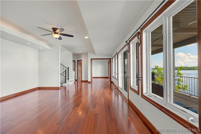1129 Beacon Pointe Cir, Lake Ozark, MO 65049 - unfurnished room featuring stairs, wood finished floors, a ceiling fan, recessed lighting, and a water view
